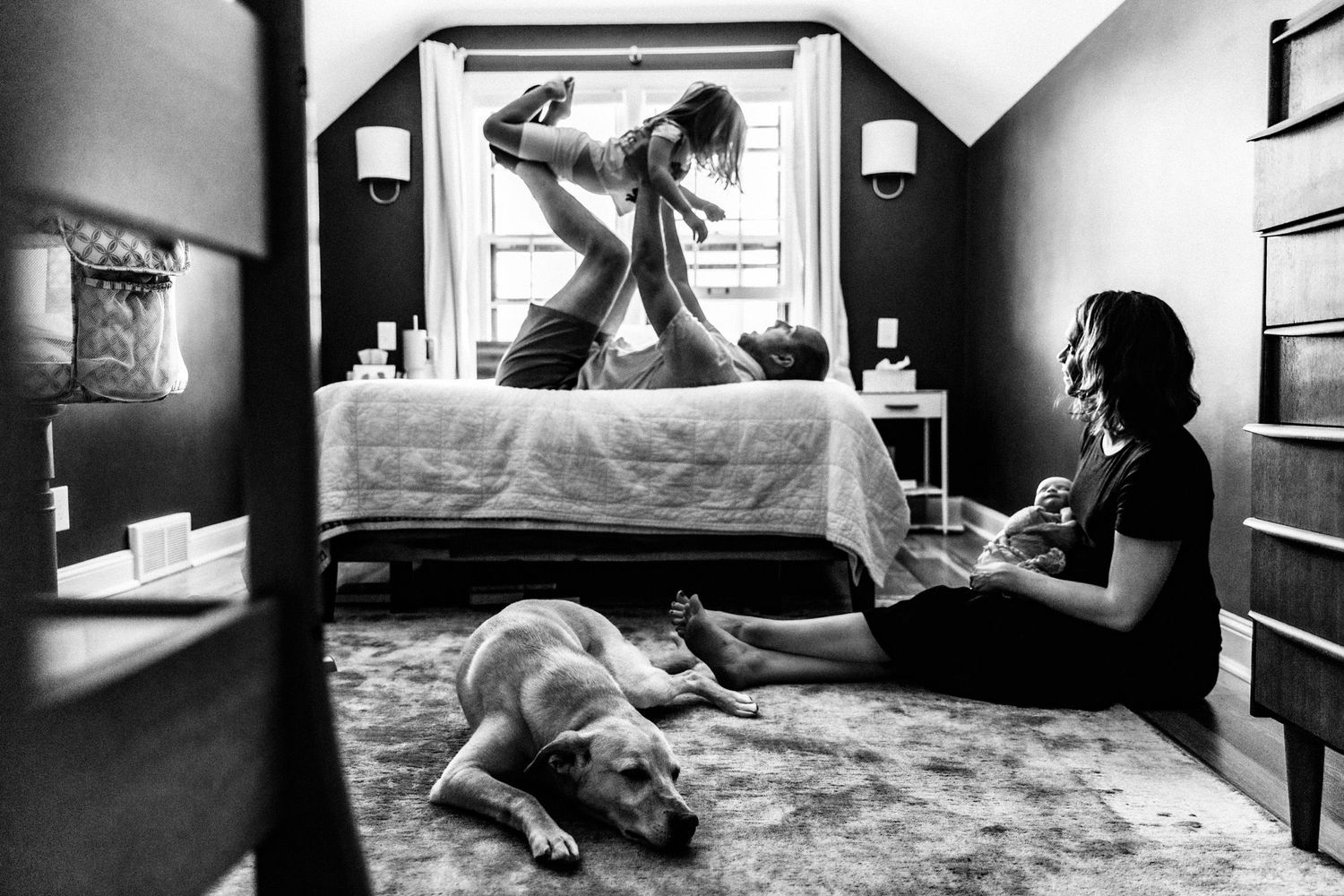 Documentary family photo in Minneapolis of a family with their newborn and dog playing at home