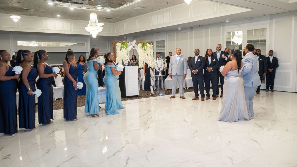 Wedding reception in elegant white venue with guests in formal attire.