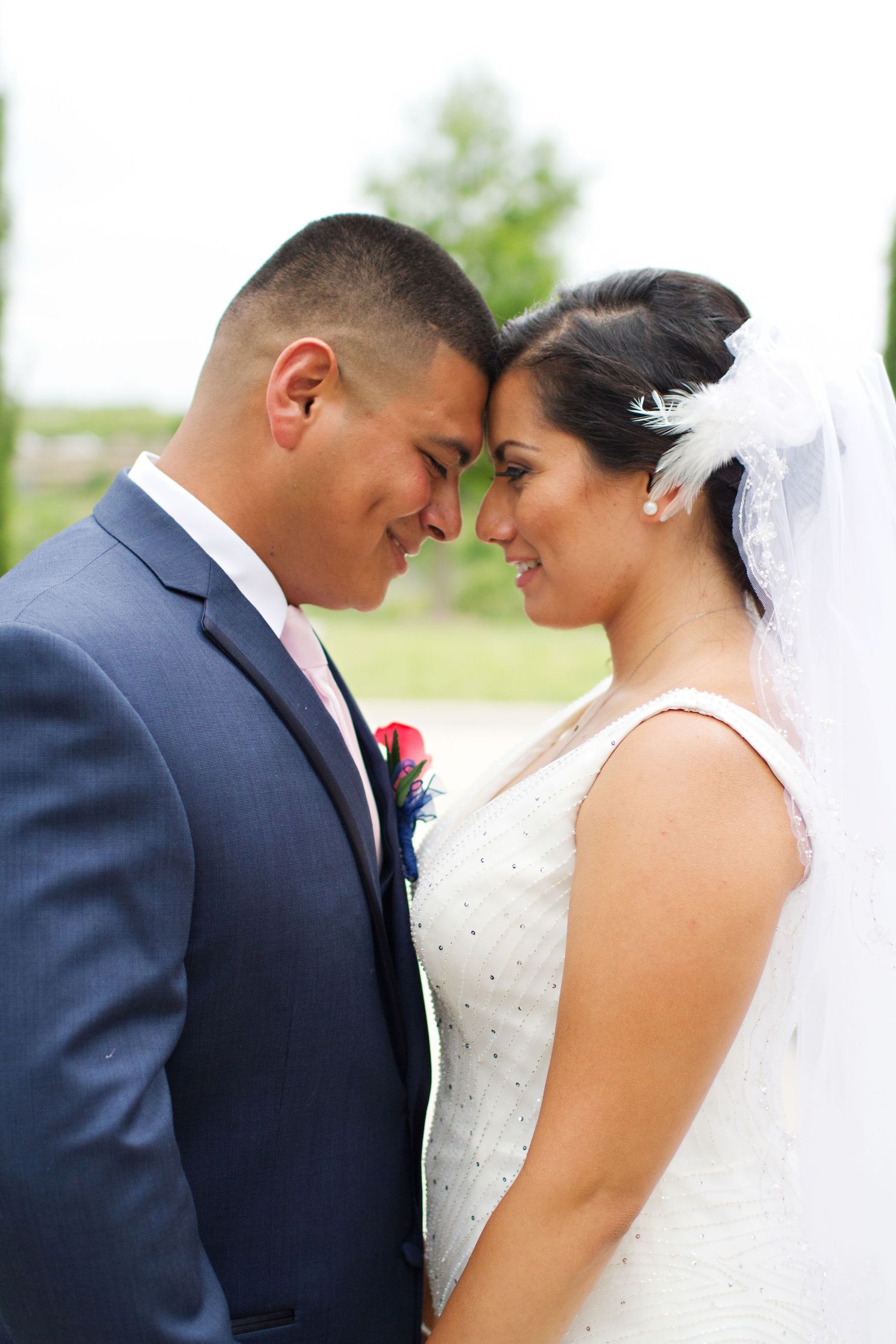 Bride and Groom touching forehead to forehead holding hands close
