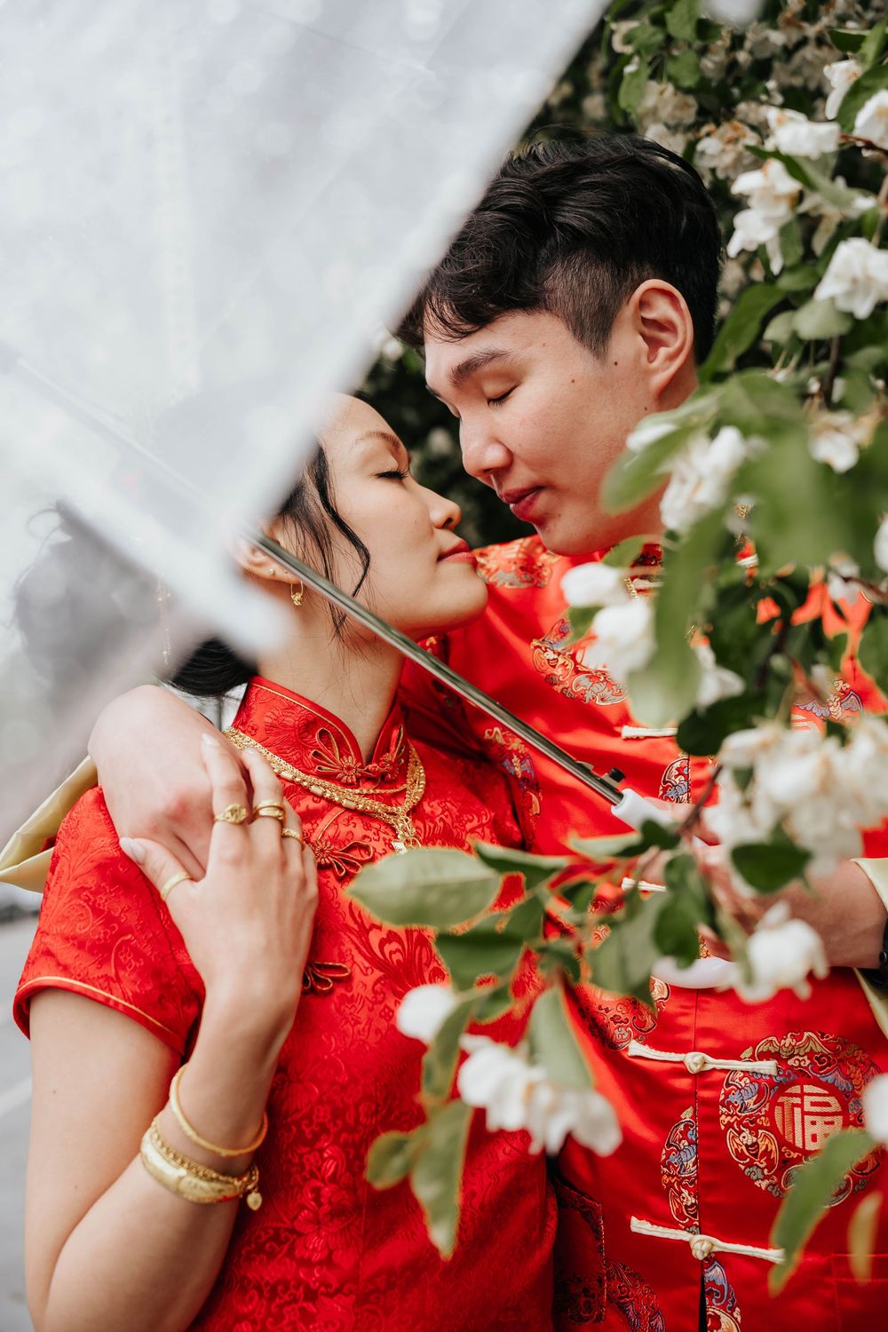 Close-up shots of a couple in traditional Chinese wedding attire sharing intimate moments among cherry blossoms.