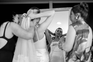 Black and white photo of people dancing and celebrating at a wedding reception.