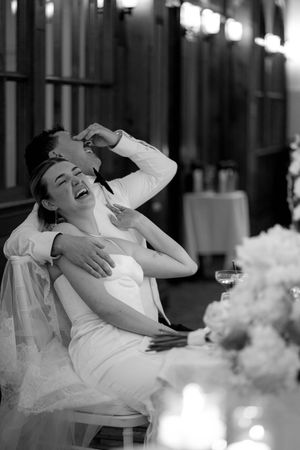Black and white wedding photo series showing a couple laughing joyfully together at their reception.
