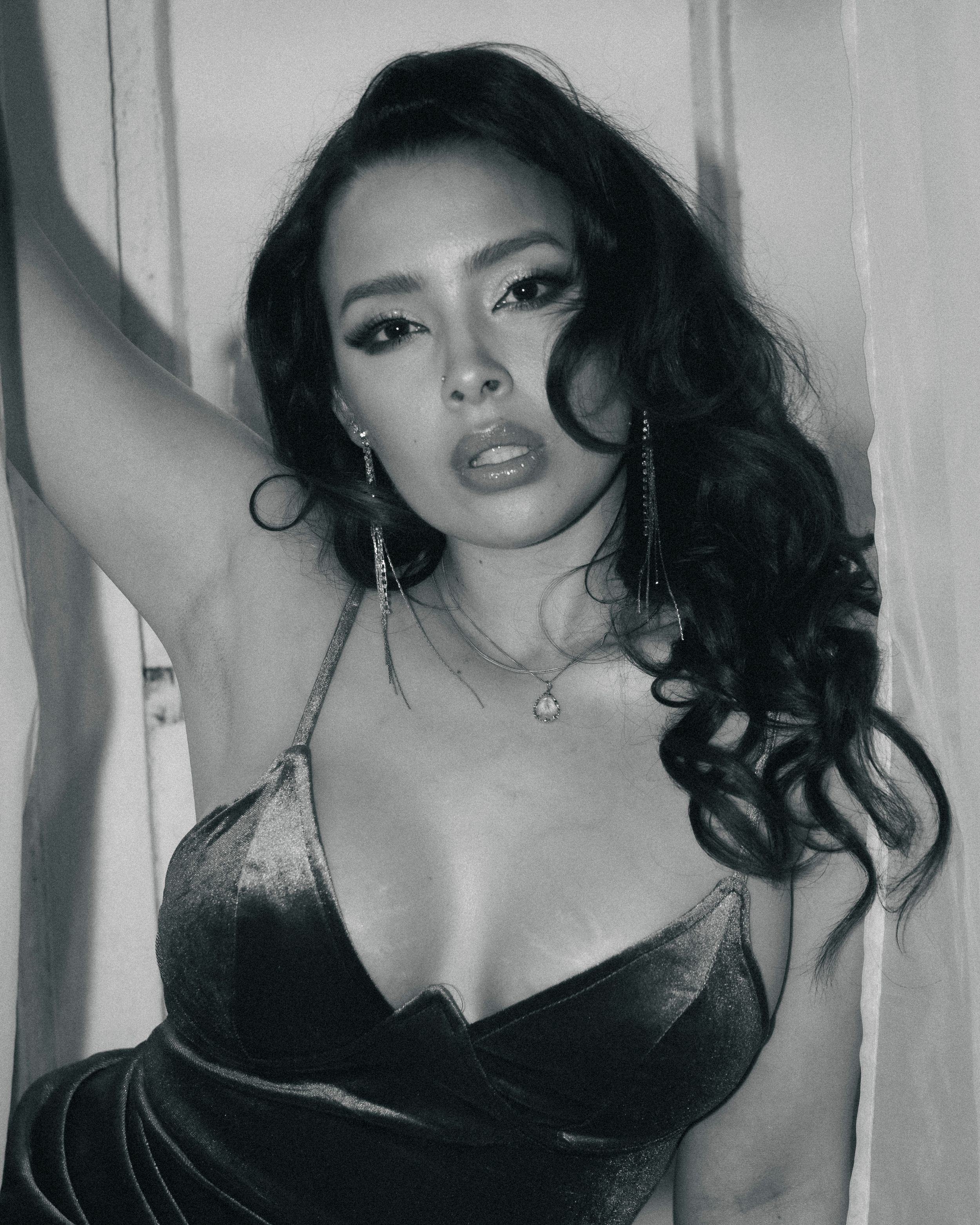 Black and white portrait in lingerie featuring dramatic lighting and flowing dark hair.