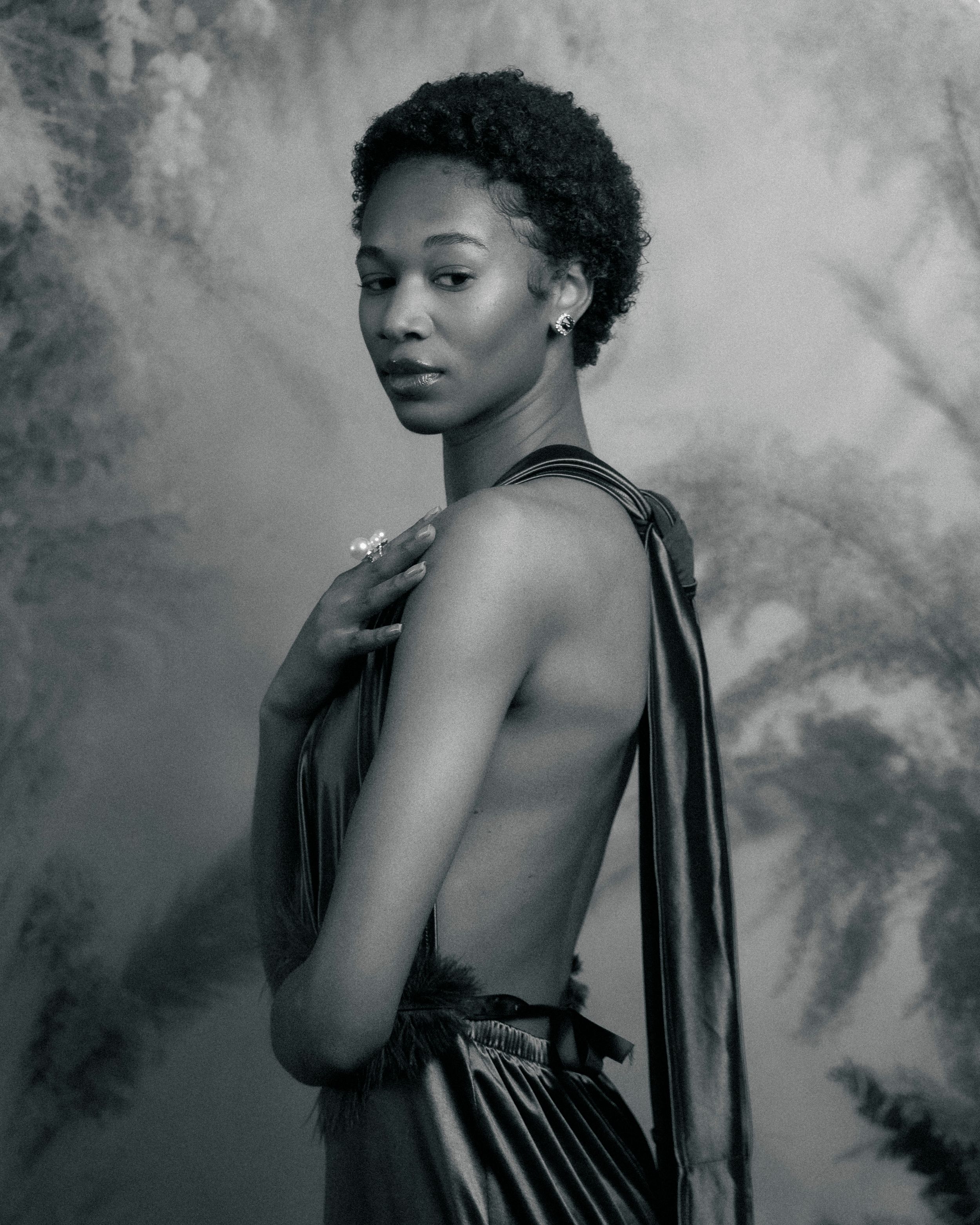 Artistic black and white photo showing elegant backless dress against smoky background.