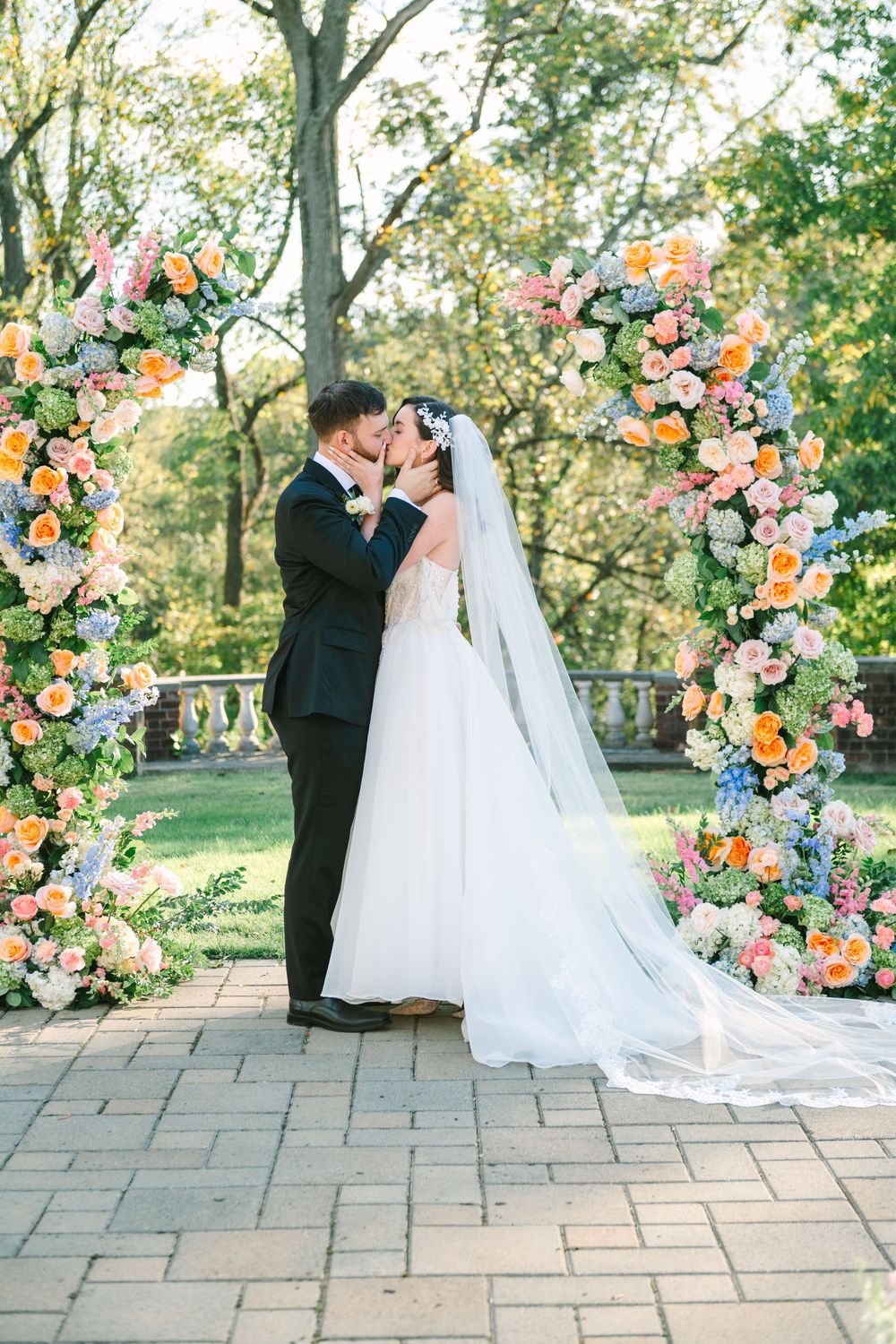 Close-up of a bride in white dress and groom in pink suit sharing an intimate moment.