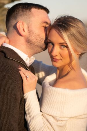 An intimate close-up portrait captured in warm sunset lighting at the beach.