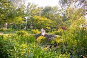 Wide landscape view of garden with stone structures and lush greenery.