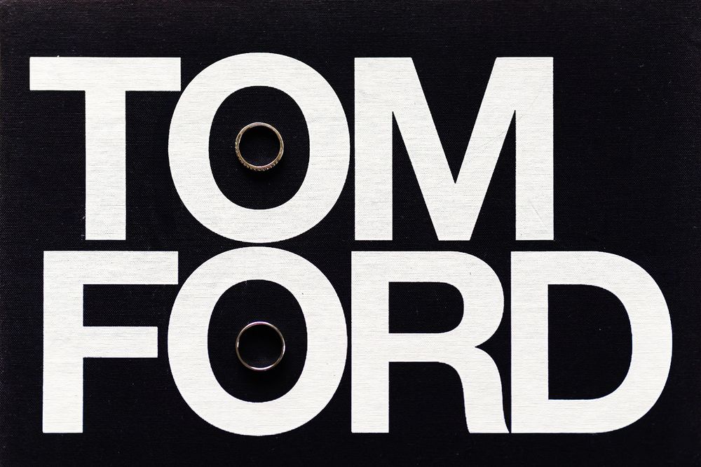 Tom Ford logo design in bold black text on dark background with two circular elements.