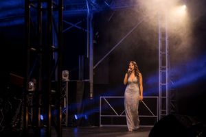 Singer - Ilish Retallick performing on stage at the 2025 ACC Christmas Carlos wearing a long silver Dress, photo by Jason Robins