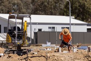 Albury Wodonga commercial photography by Jason Robins showing civil earthworks, a mini excavator, and a worker shovelling dirt on site.