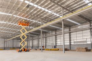 Albury Wodonga industrial photography by Jason Robins showing contractors using a scissor lift inside a large commercial warehouse.