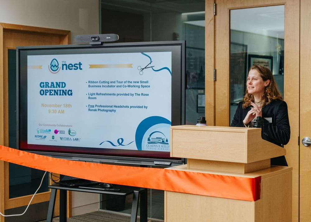 A grand opening event display with a Nest banner and speaker podium setup in an office space.
