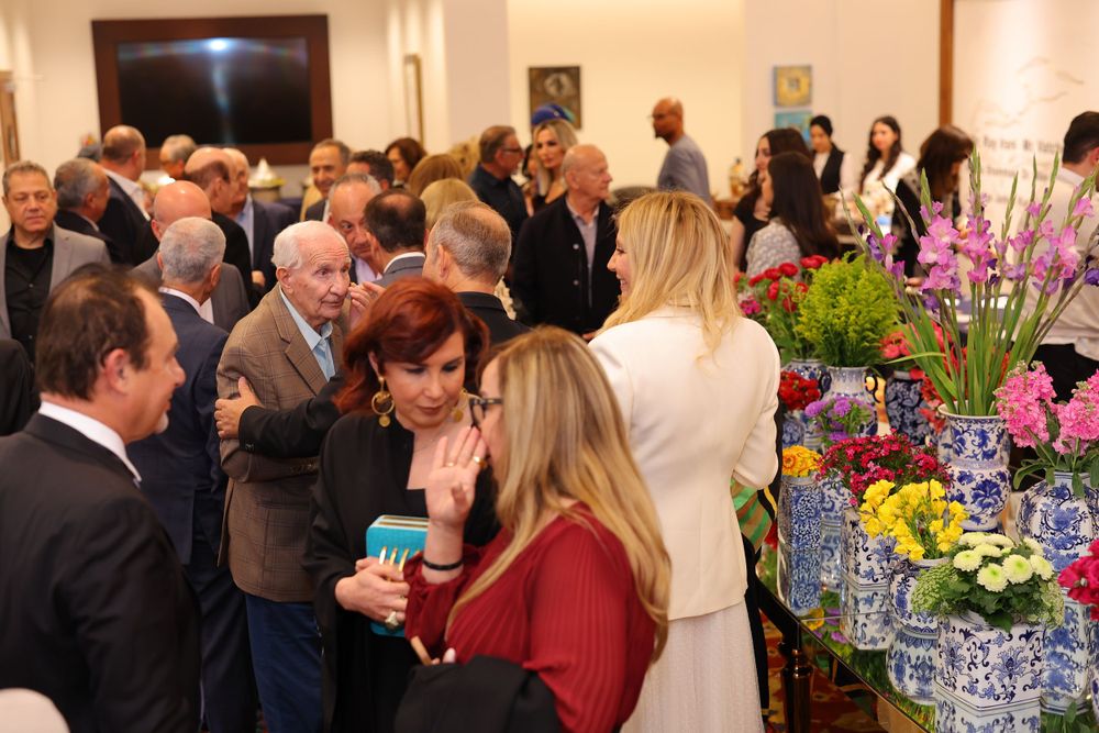 Social gathering with buffet table featuring colorful floral arrangements and refreshments.
