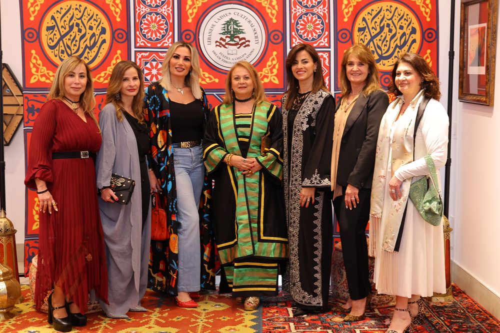 Group photo of women in traditional and modern dress against ornate Middle Eastern wall design.