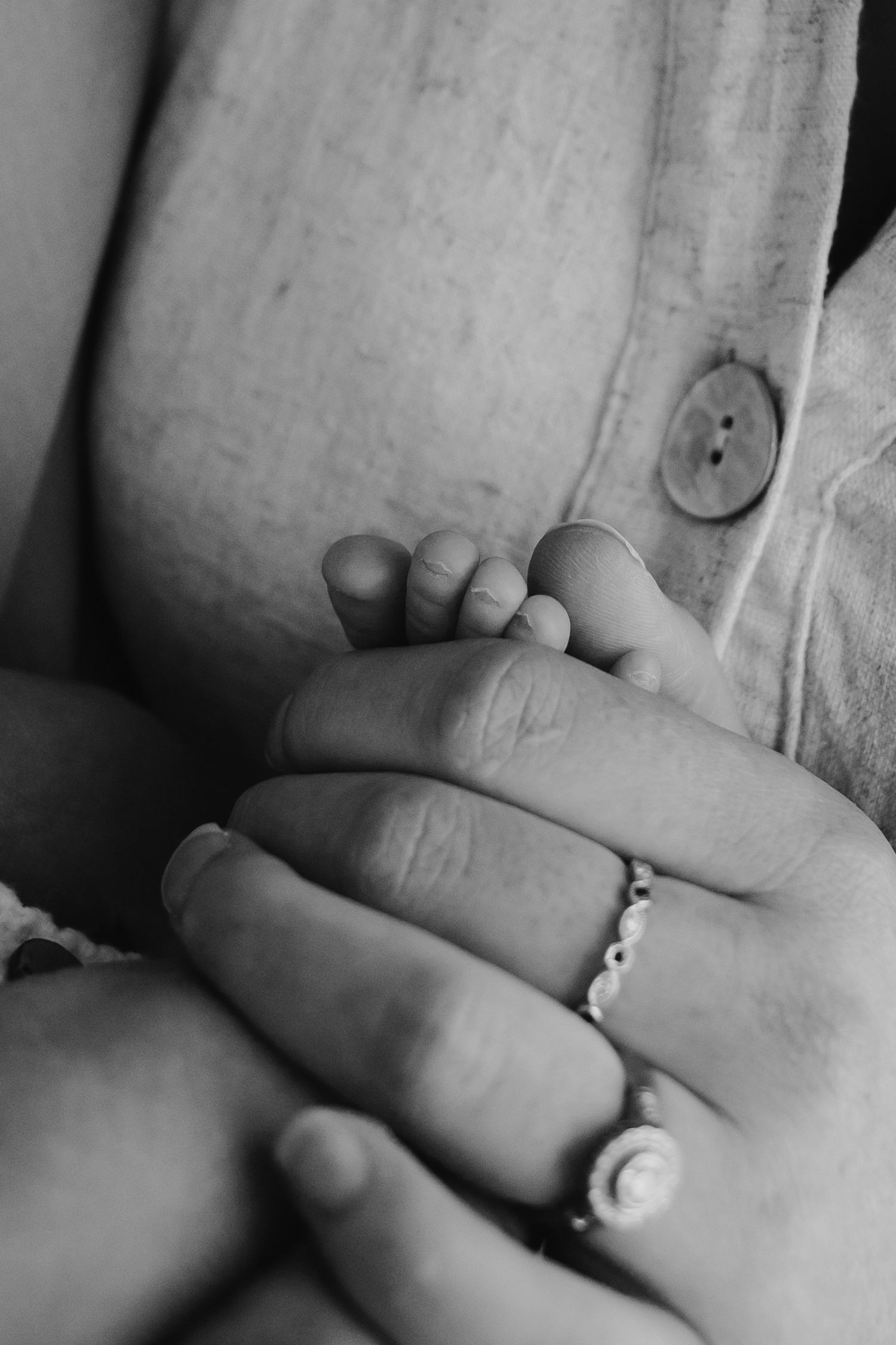 Close up of newborn baby toes in mum's hand.