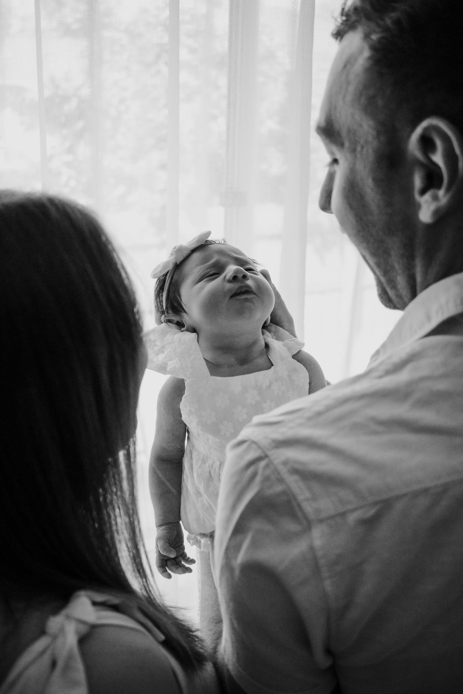 Mum and dad looking at baby.