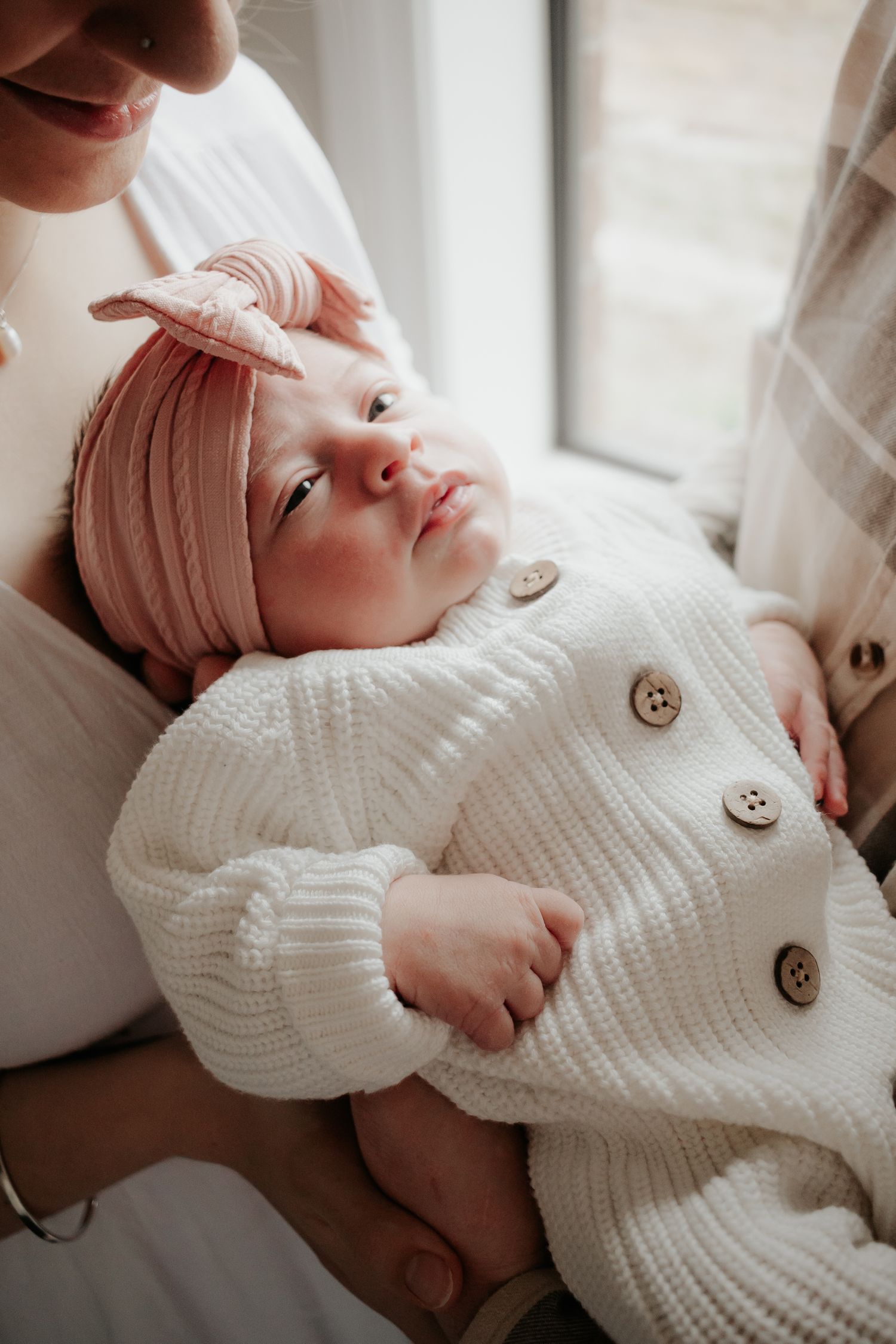 Close up of baby being held between mum and dad.