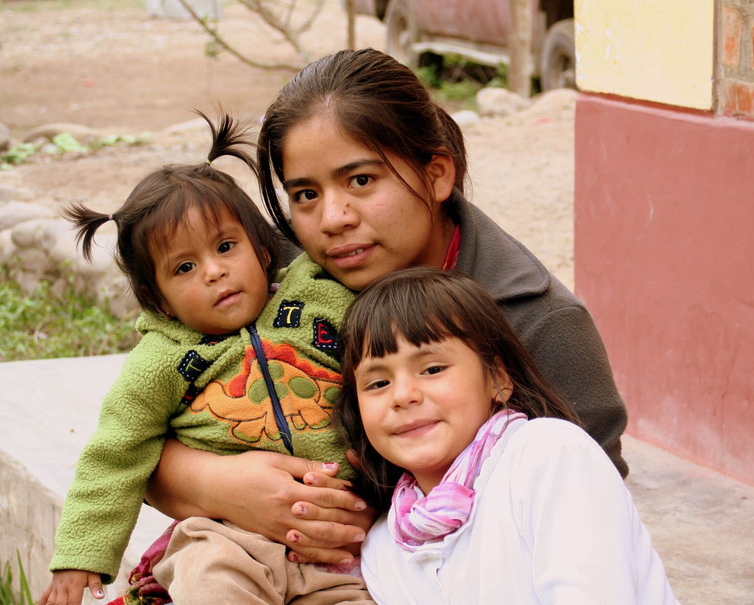 three girls snuggling and looking at the camera