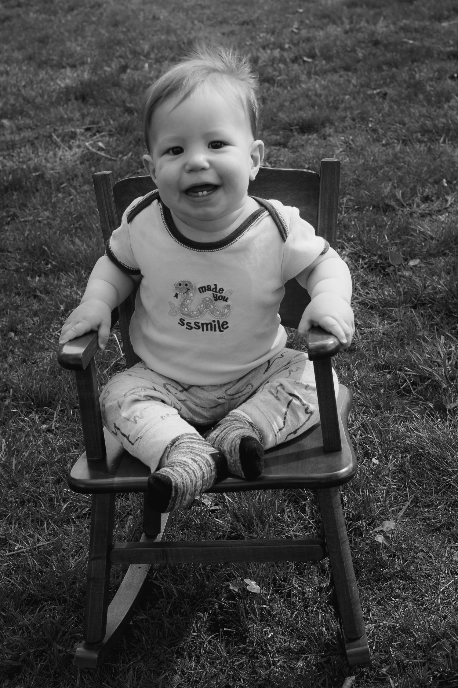 smiling baby in rocking chair, black and white