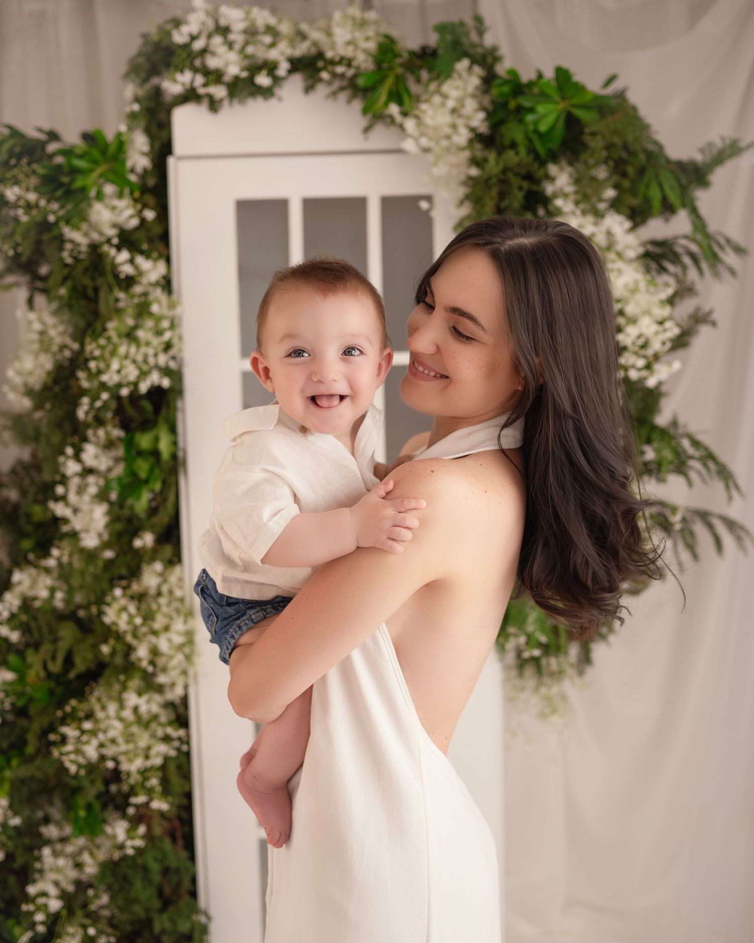 A tender moment between parent and child laughing together against a floral backdrop.
