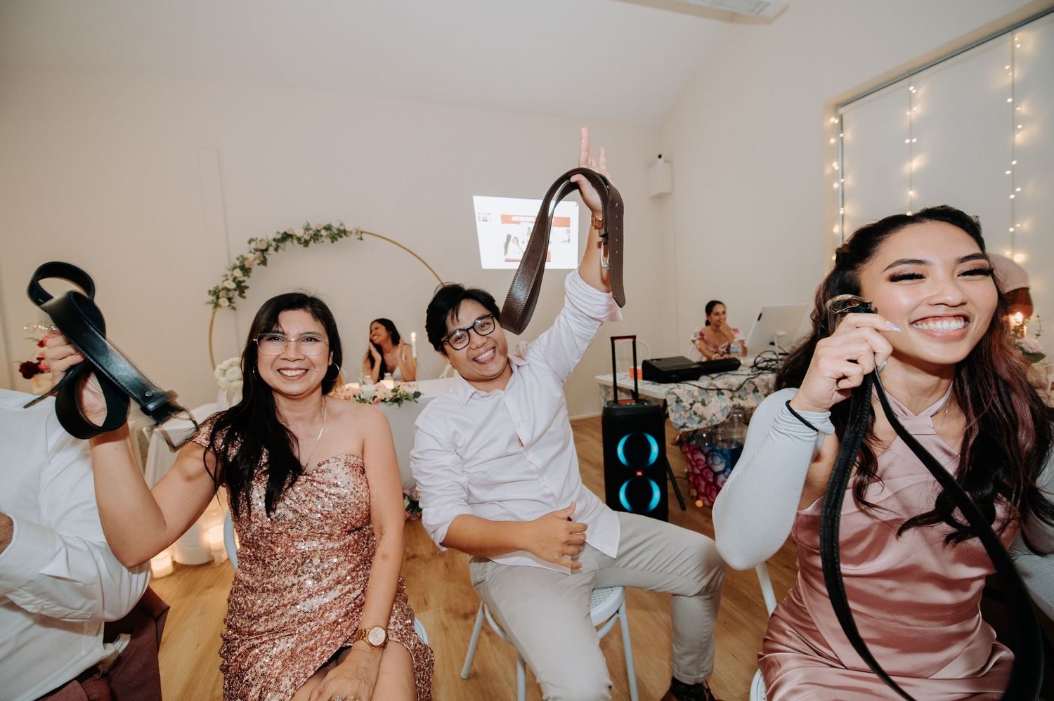Joyful wedding celebration with people dancing and having fun at an indoor reception.
