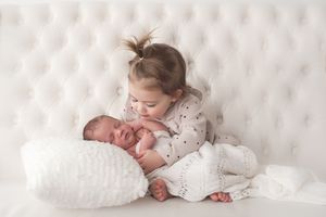 toddler holding newborn sibling in studio natural family photography Halifax