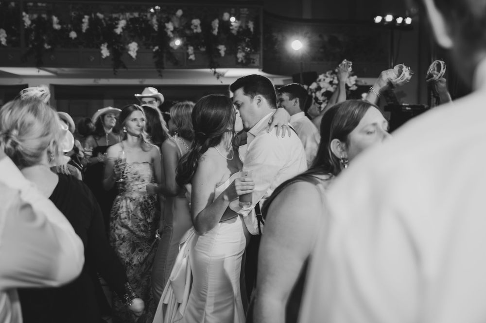 Black and white photo of a crowded dance floor with people dancing at a formal event in vintage attire.