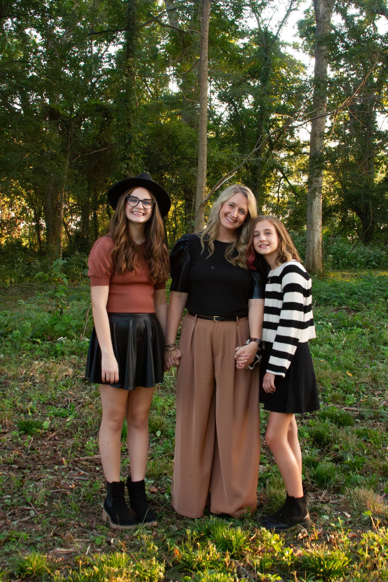 a mother with two preteen daughters standing in a grassy area with trees in the background - taken by Delta Blossoms Photography Manila AR