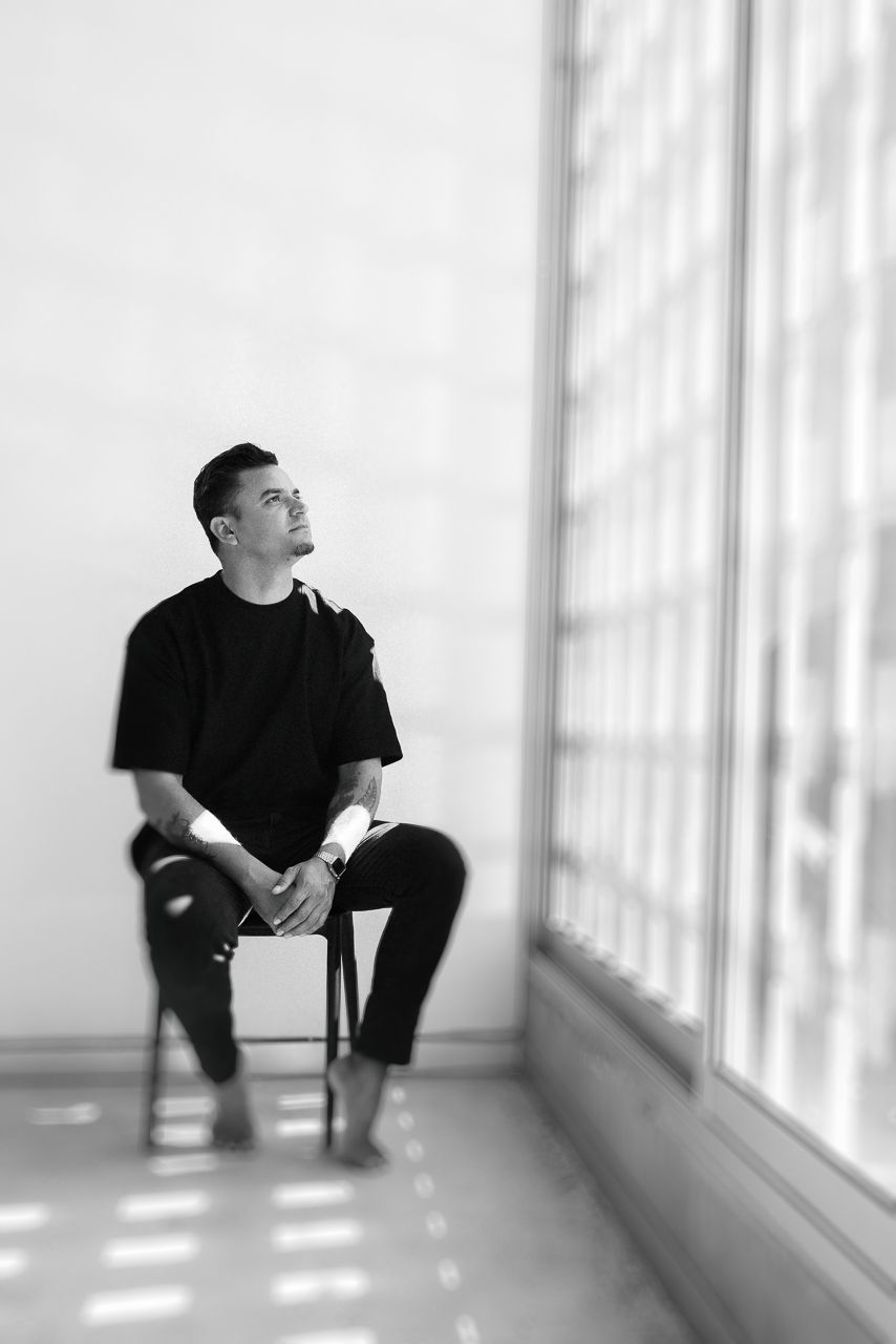 Puerto Vallarta family photography, black and white portrait of a person sitting in a bright hallway with dramatic window light and shadows.