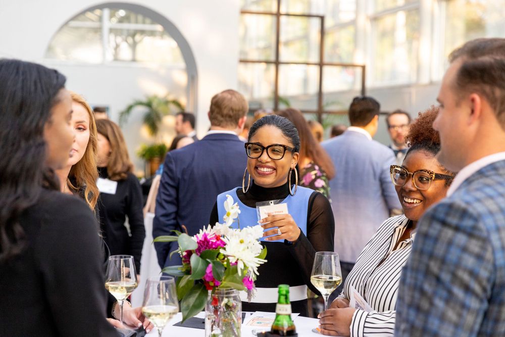 People enjoying conversation and drinks at a diverse business networking reception.