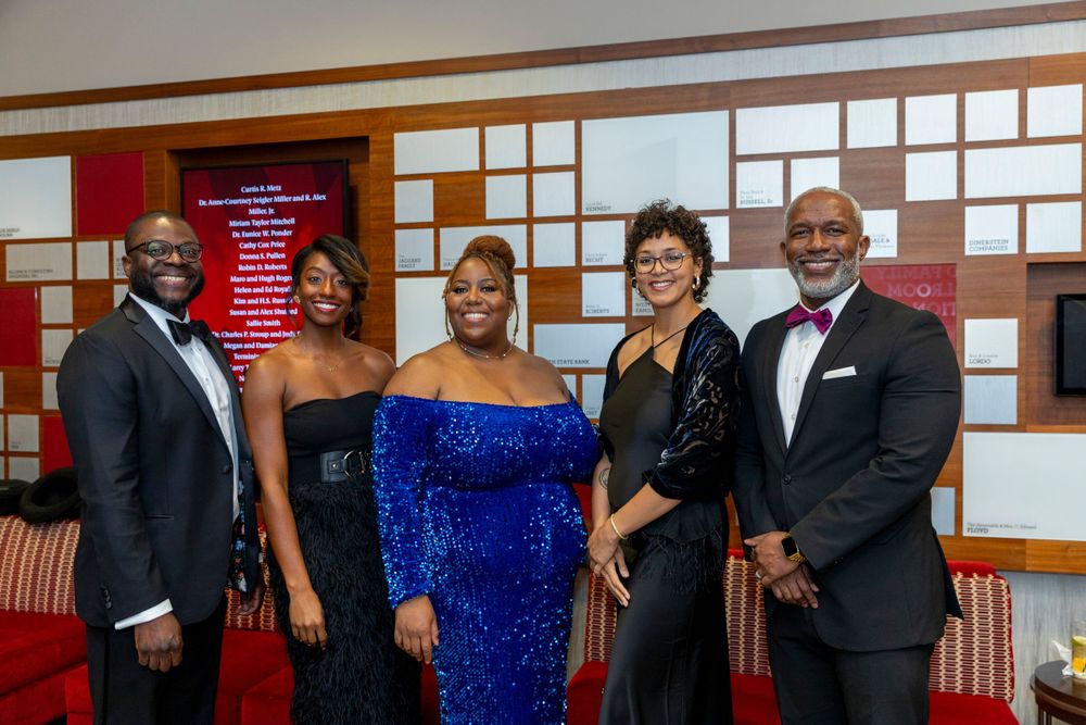 Group photo of well-dressed attendees at a formal evening event.