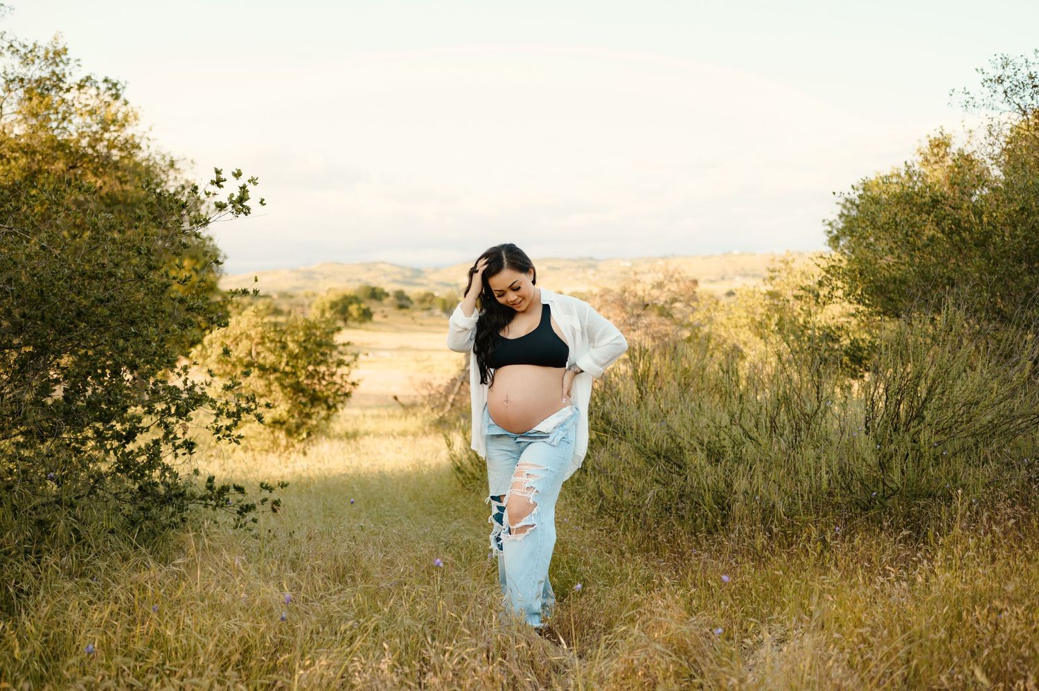 pregnant woman posed in Ojai field during her sunset maternity photoshoot by Ventura County photographer