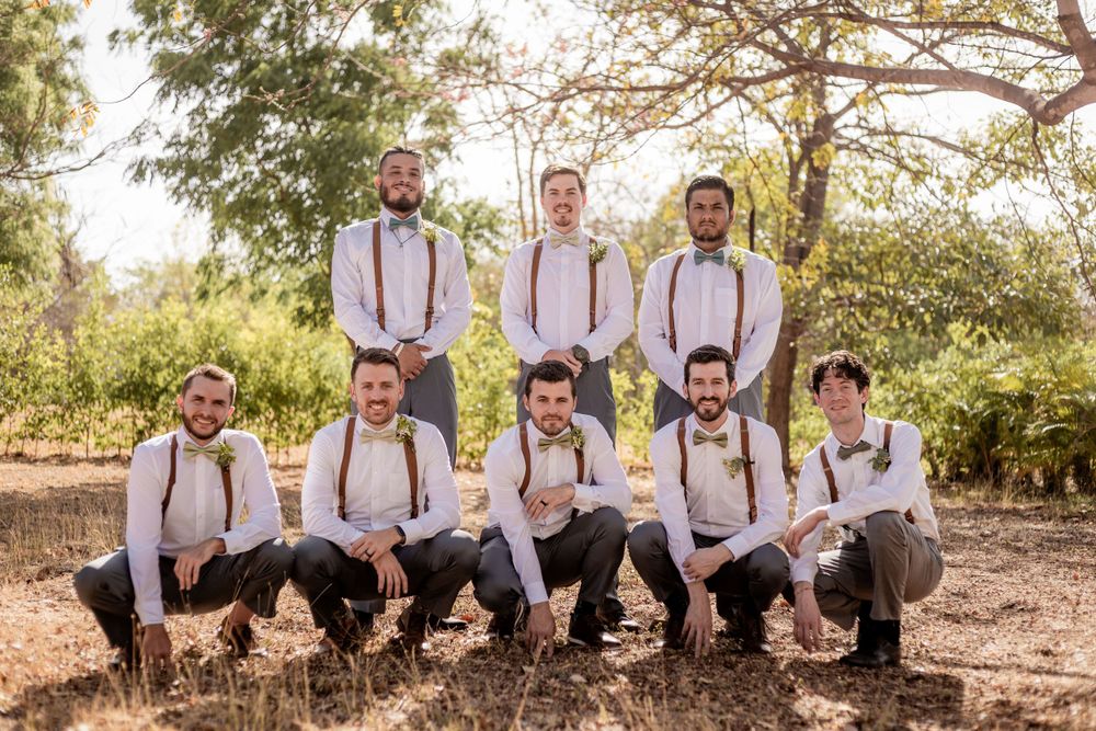 Groomsmen pose together in matching white shirts with suspenders and bow ties at outdoor wedding. Guanacaste, Costa Rica