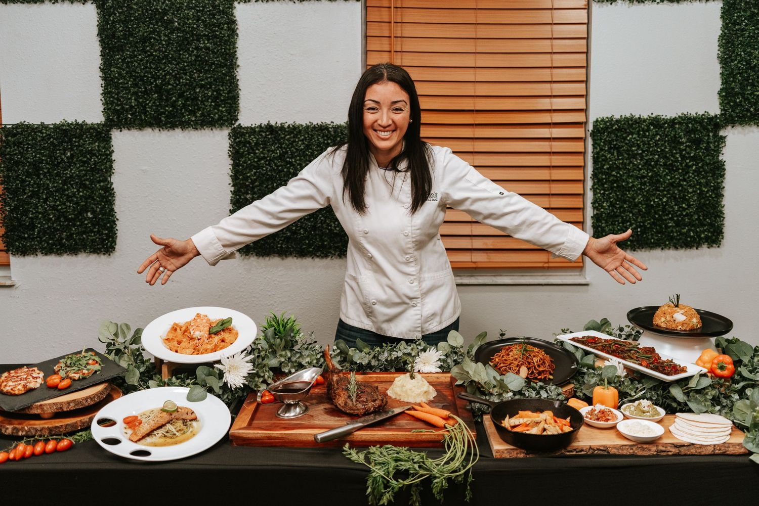 Elegant catering spread with multiple dishes and decorative garnishes on dark wood table.