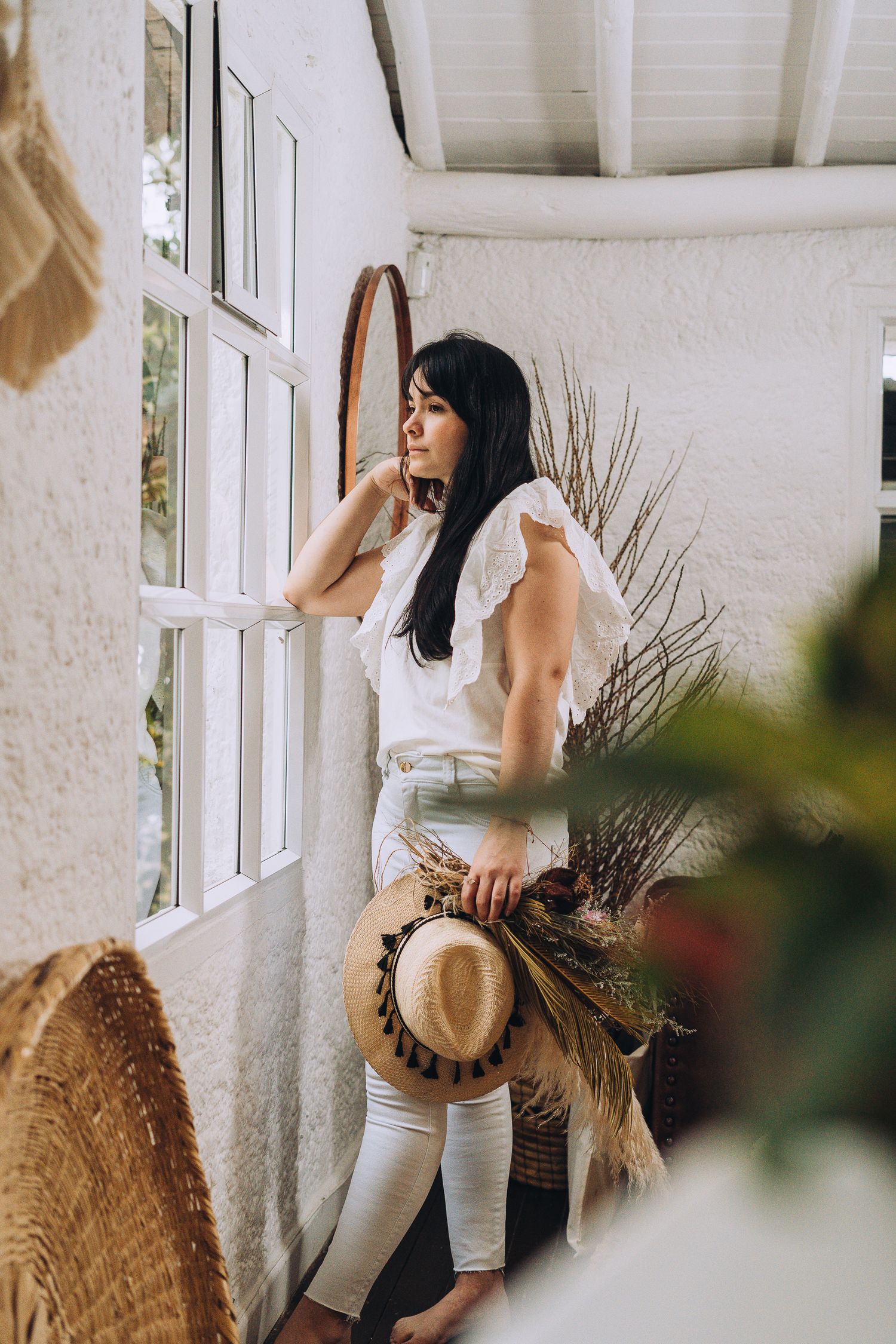 Dreamy interior scene with white walls, window light, and decorative dried pampas grass arrangements.