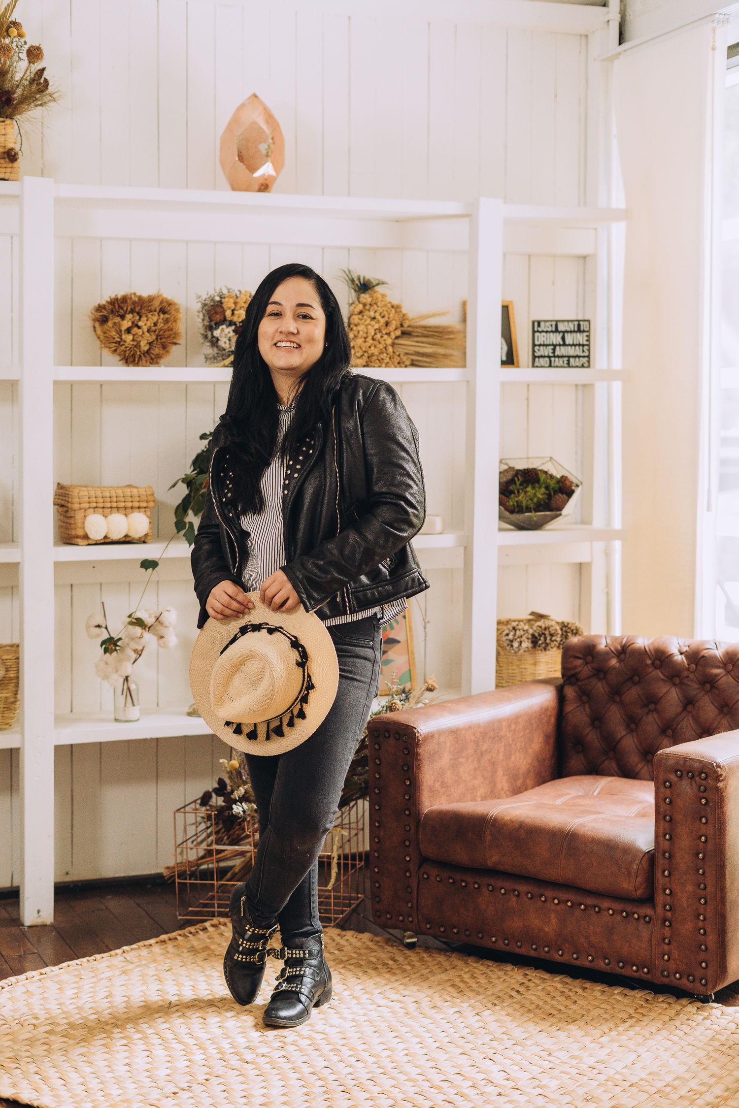 Modern bohemian interior with white shelving, leather accent chair, and natural decor elements.