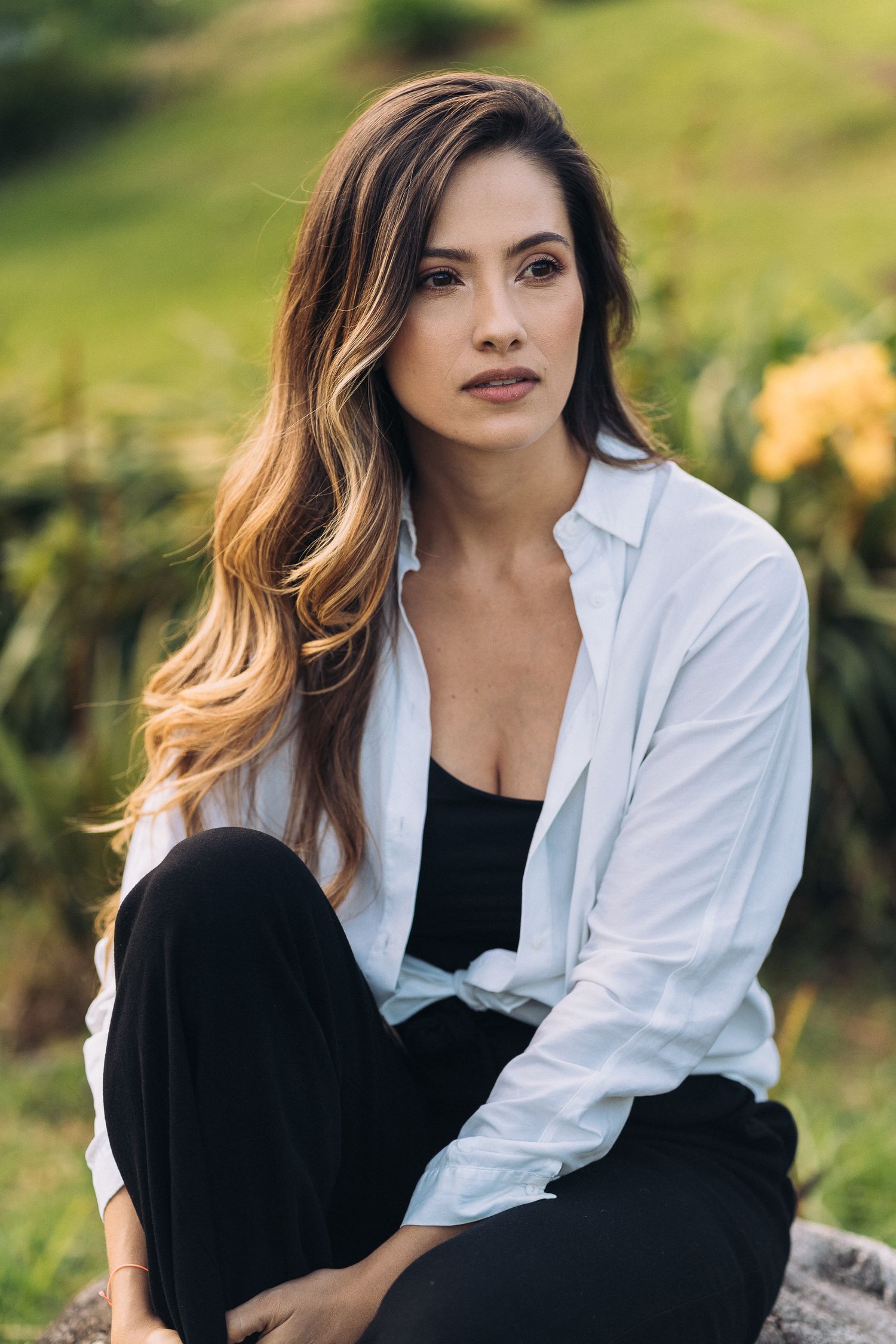 Casual outdoor portrait against a natural green background with soft lighting.