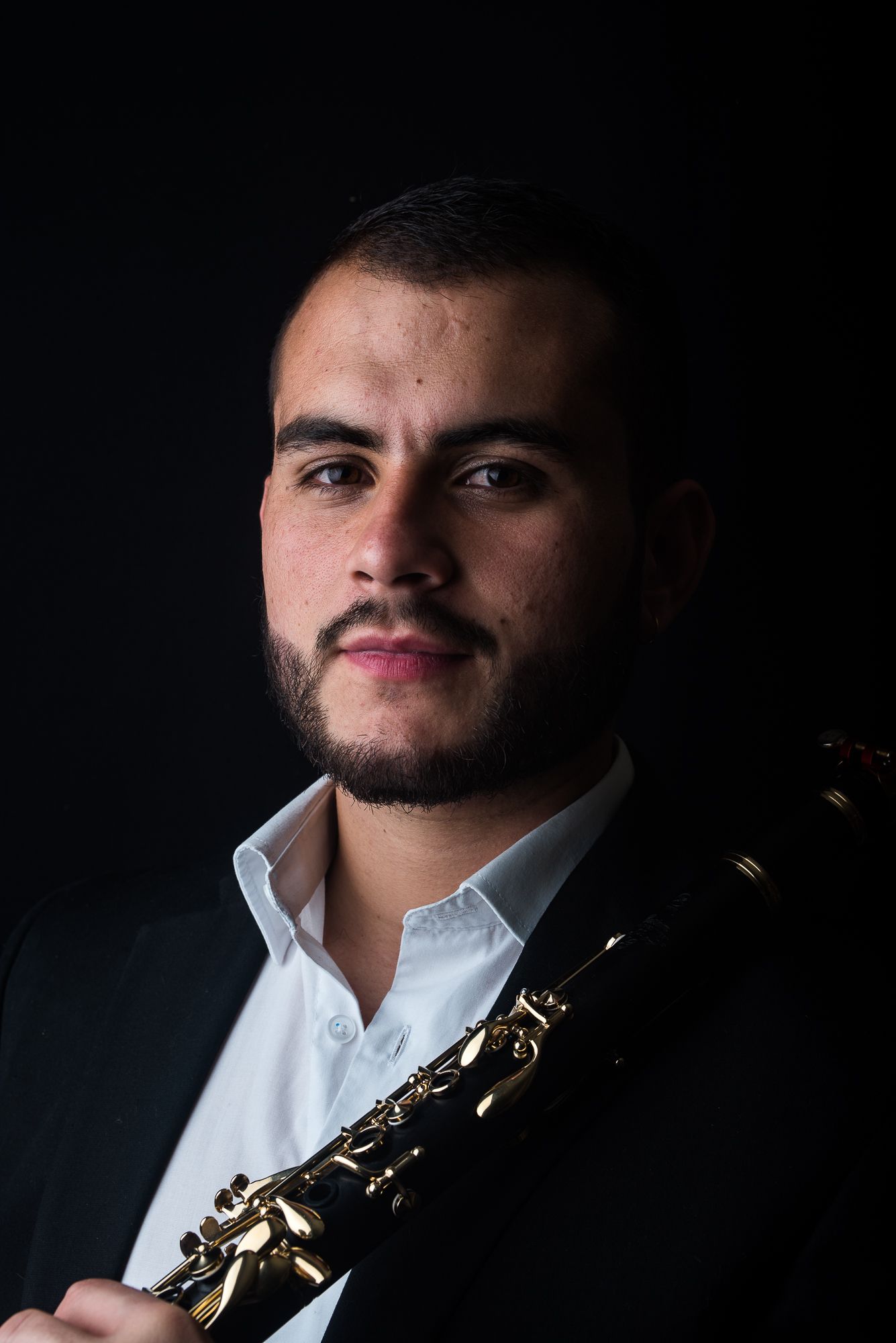 Close-up black and white portrait of musician with clarinet in formal wear.