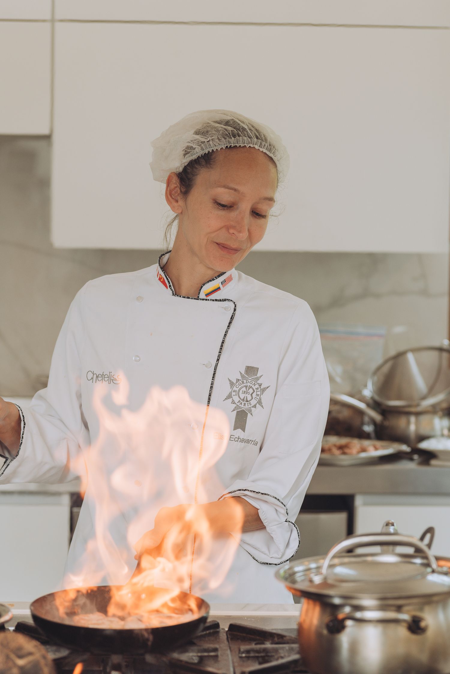 Chef cooking with dramatic flames in professional kitchen.