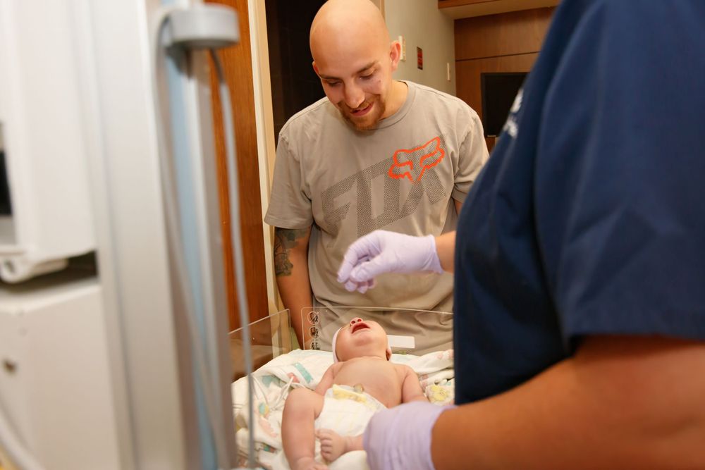Healthcare workers care for a newborn in a medical facility.