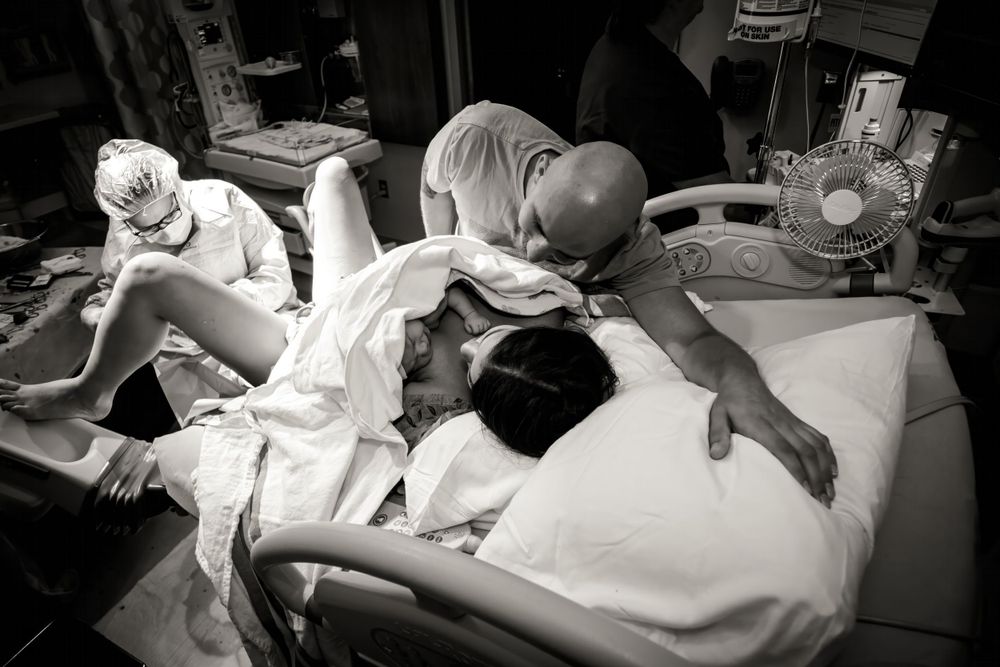 Medical staff attend to a newborn baby in a hospital delivery room.
