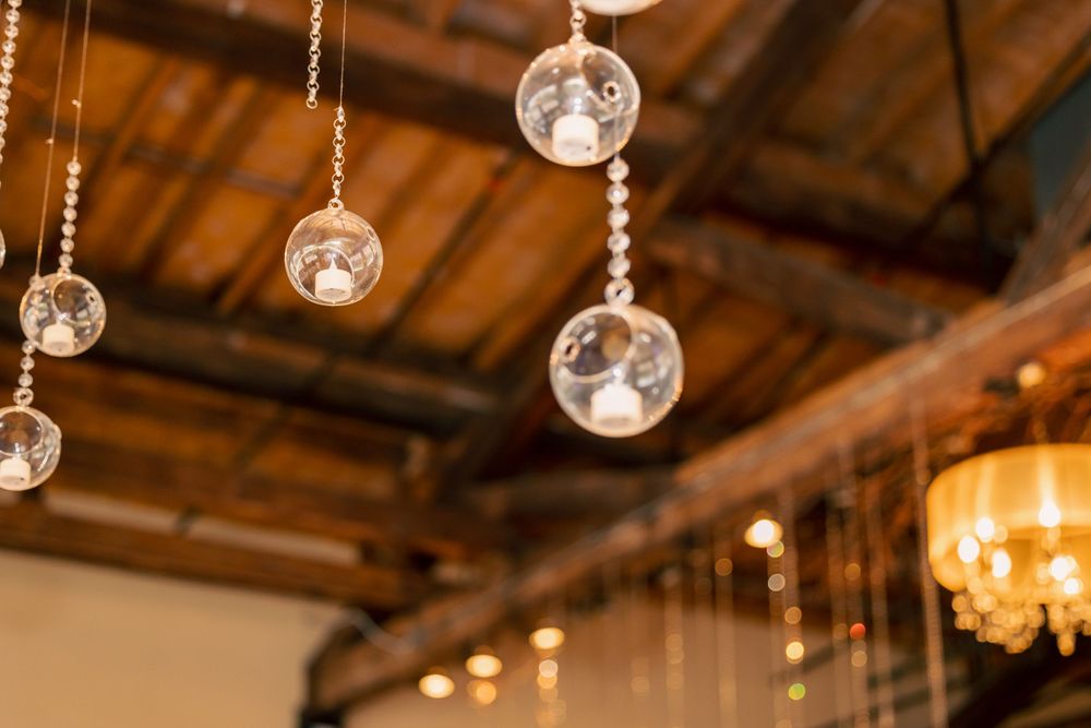 Decorative glass orbs hanging from wooden ceiling at an event venue.