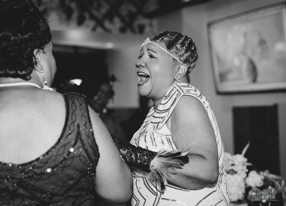 A group of people dancing and performing in a black and white vintage photograph.