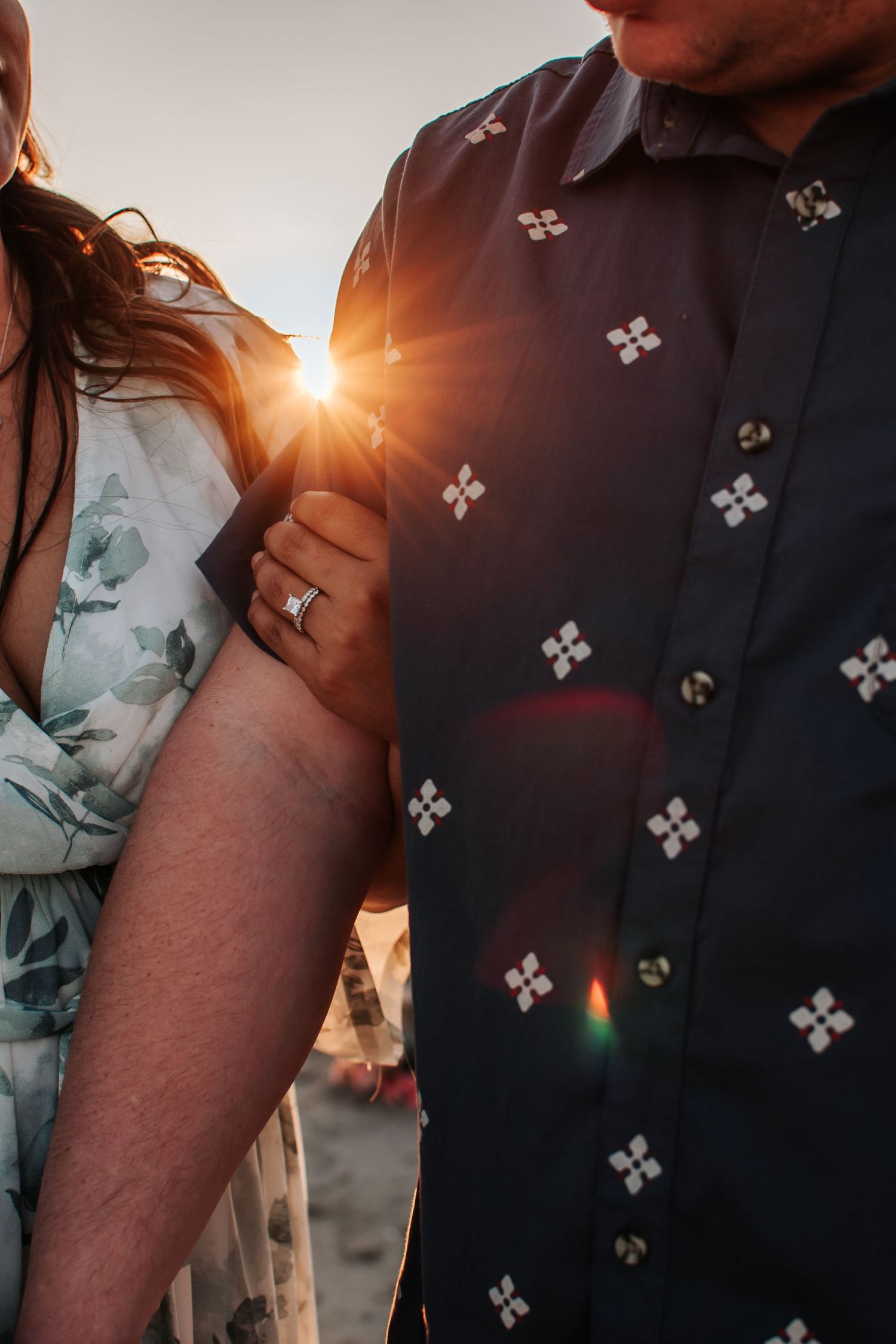 Close-up of couple holding hands with sun flare at sunset in Royal City, Washington.