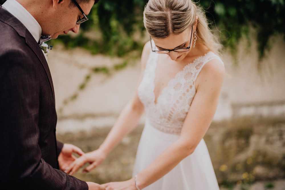 A close-up moment of a couple exchanging rings during their wedding ceremony.