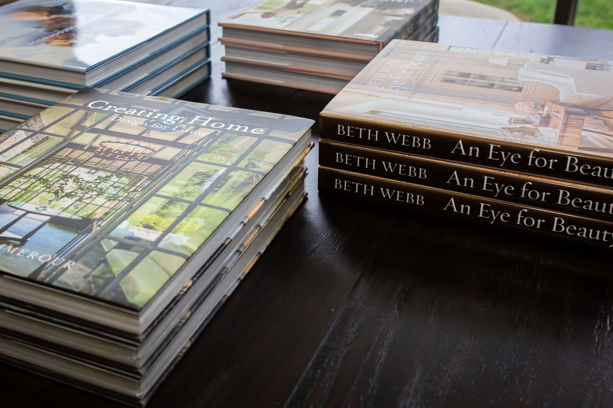 Stacks of coffee table books including 'An Eye for Beauty' arranged on a dark wooden surface.
Commercial Photography