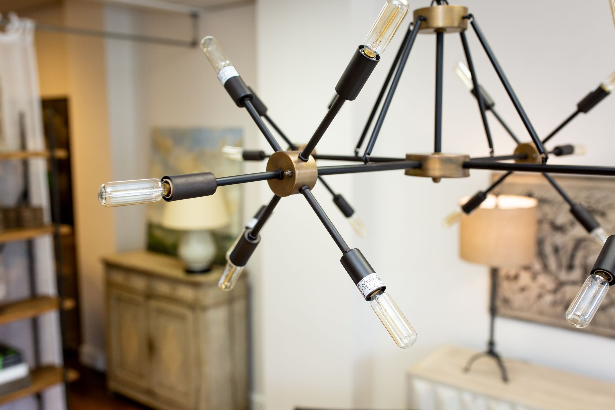 Modern sputnik chandelier with glass tubes and brass details photographed against a white wall.
Commercial Photography