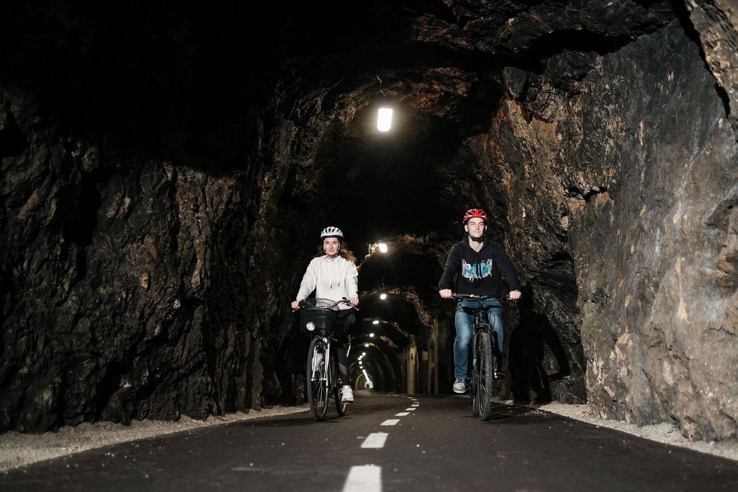 Kolesarja vozita skozi osvetljen tunel po urejeni kolesarski poti Brestanica Foto Colarič