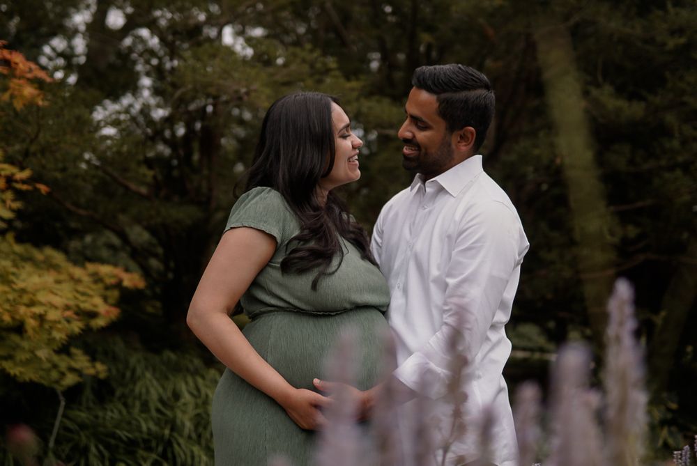 An expecting couple sharing a look in the garden