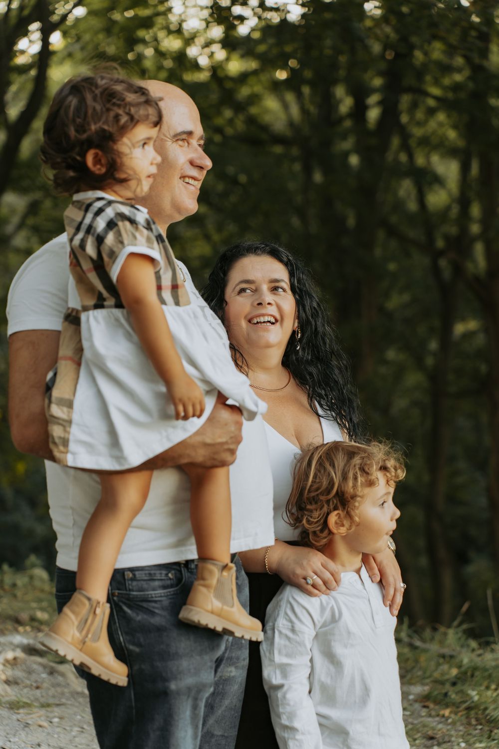 Parents holding their two children in the forest